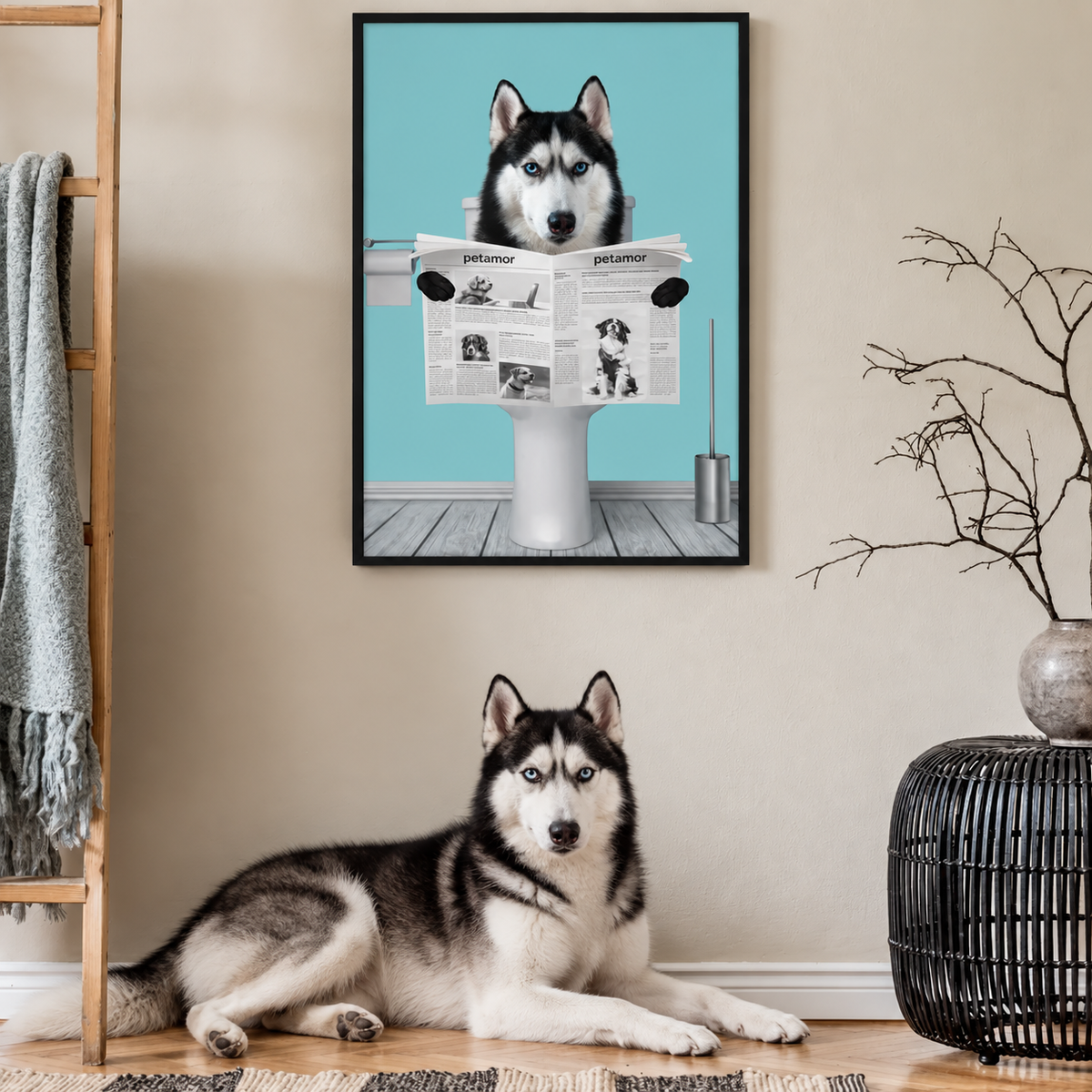 Husky sitting on the floor in front of a framed poster of a dog reading a newspaper.