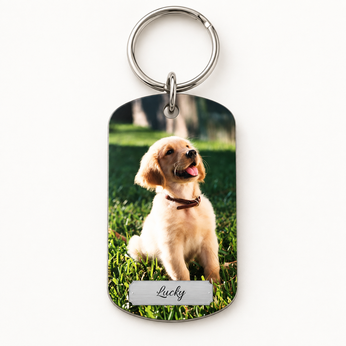 Personalized keychain with photo of a dog and engraved name on a silver surface.