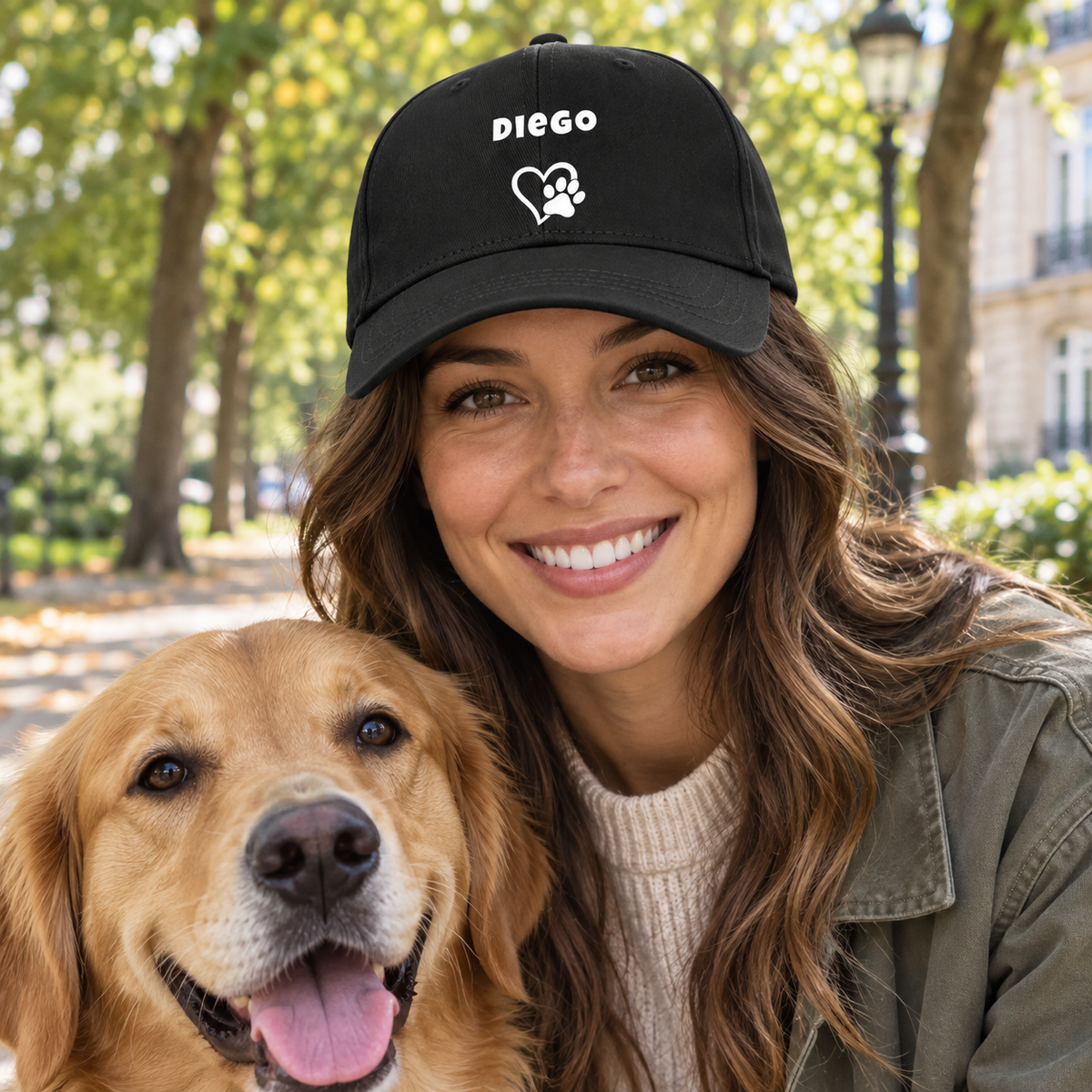 Black cap with the dog name “Diego”, heart and paw, worn by a smiling woman with a golden retriever.