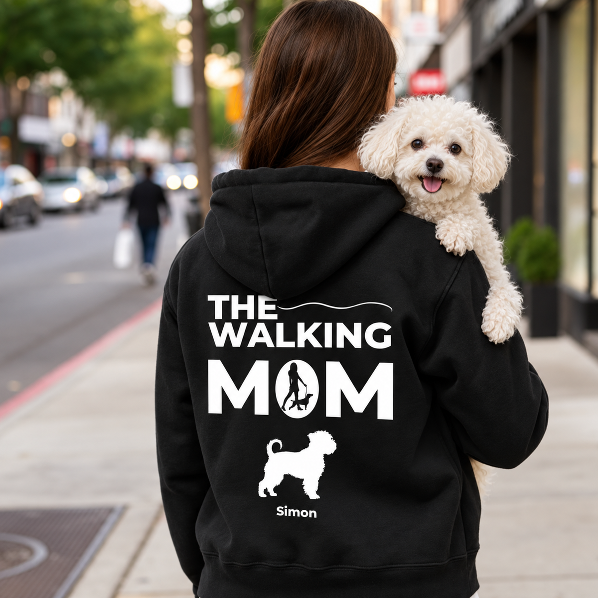 Black hoodie with personalized "THE WALKING MOM" print and dog motif. Person carrying a dog.