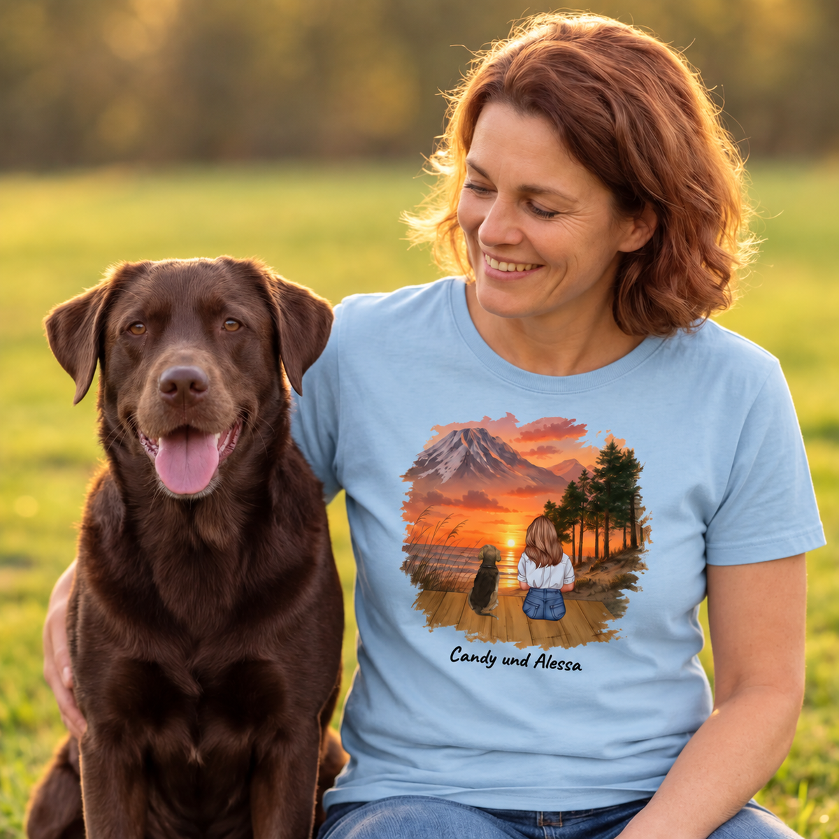 Blue T-shirt with graphic print of a woman and her dog in front of a mountain landscape.