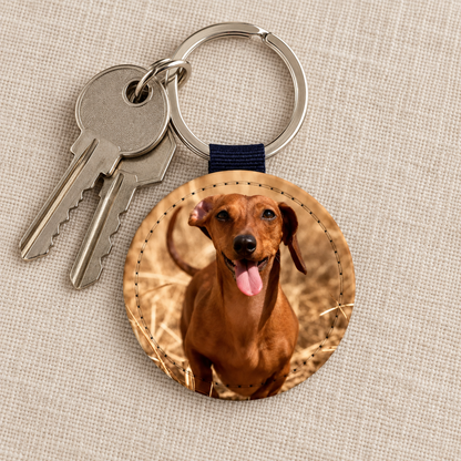 Round keychain with personalized dog photo, metal ring and blue loop.
