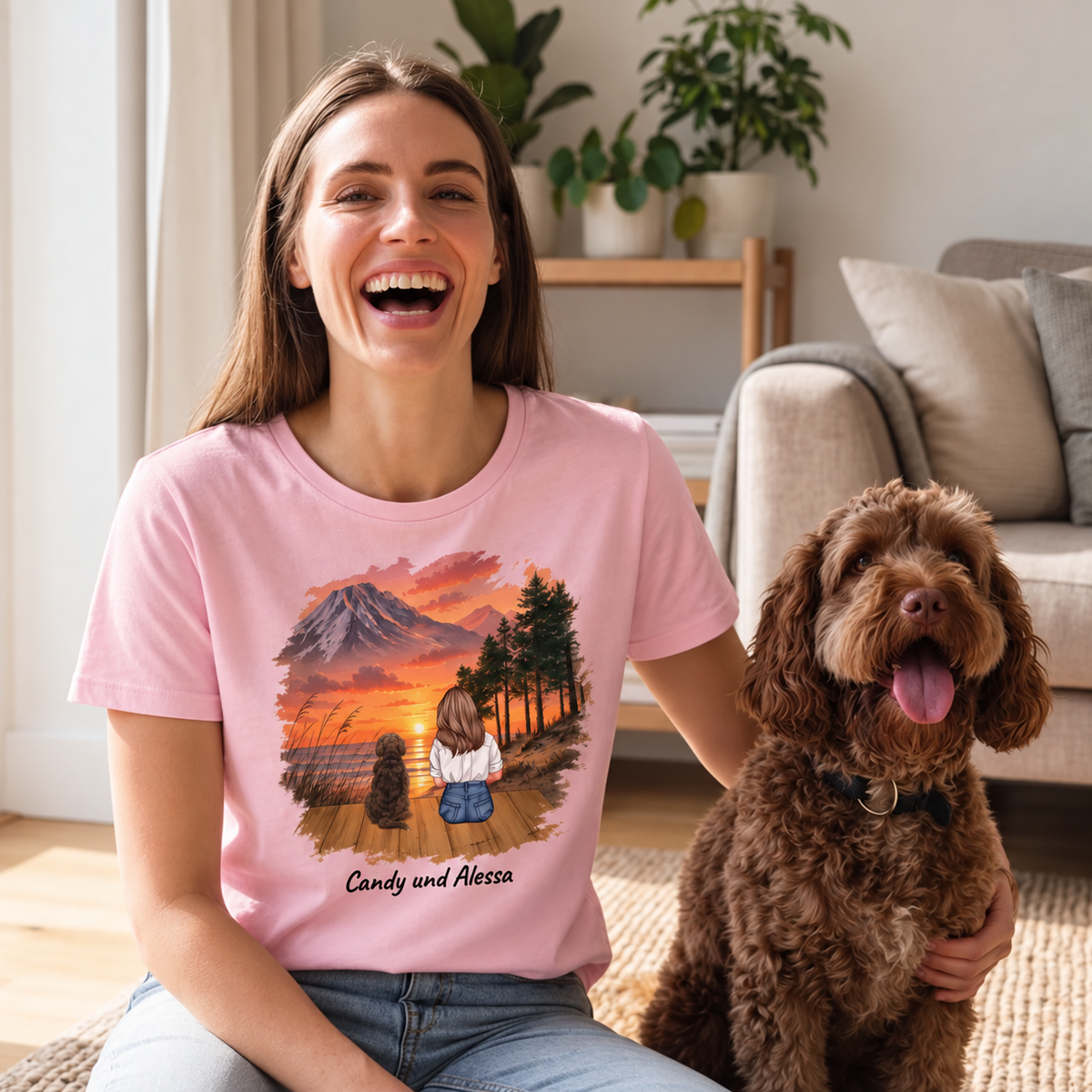 Pink T-shirt with personalized print of a woman and two dogs in front of a sunset landscape.
