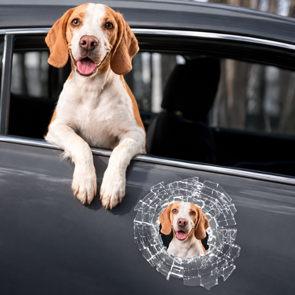 Car sticker with a peeking dog in broken-glass design, mounted on a grey car window.