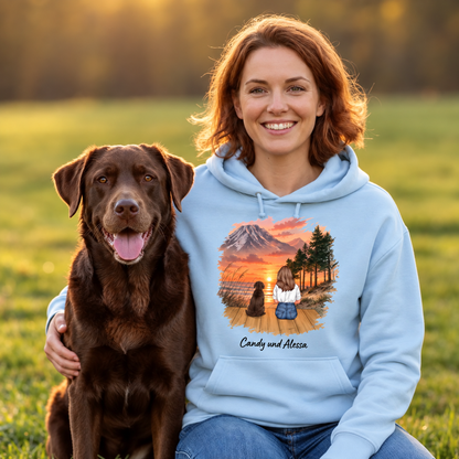 Light blue hooded jacket with graphic of a person and dog in front of a landscape at sunset.
