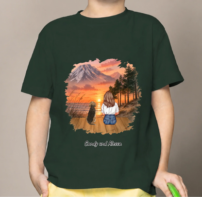 Dark green kids' T-shirt with a colorful print of a girl and a dog at sunset.