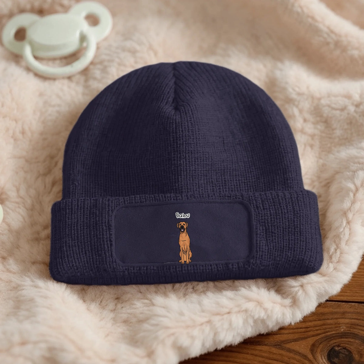 Dark blue knitted beanie with dog design and personalizable label.