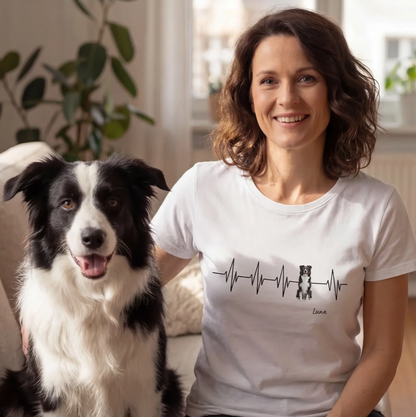 White T-shirt with heartbeat design and dog motif, personalization possible. Woman sitting on a sofa with a dog.