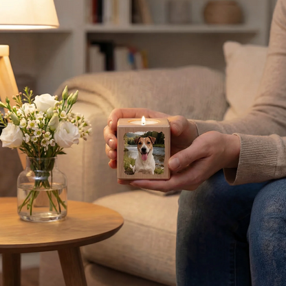 Personalized wooden candle cube with a dog photo, lit and held in the hand.