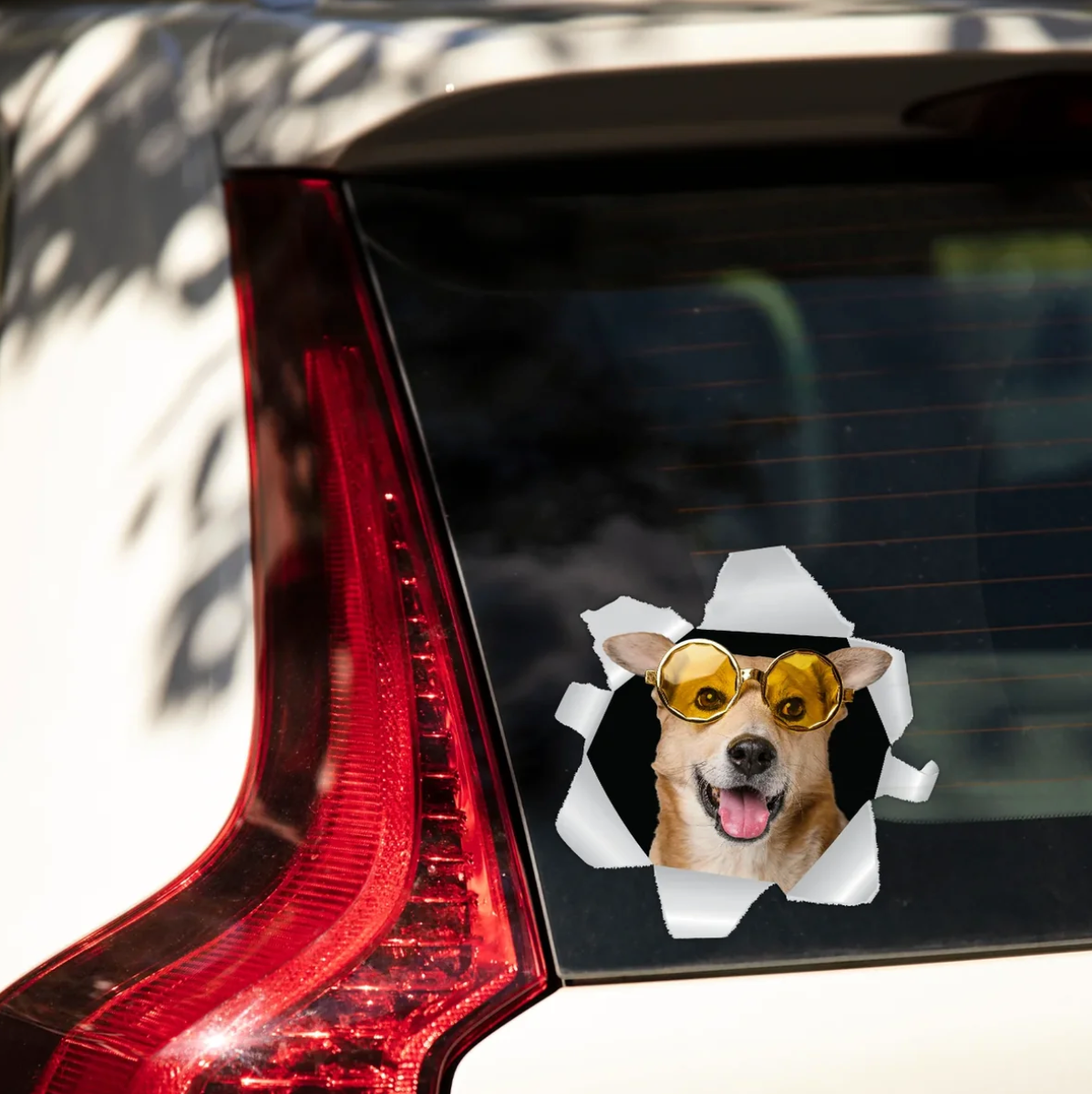 Personalized car sticker with a dog in sunglasses looking out of a torn window.