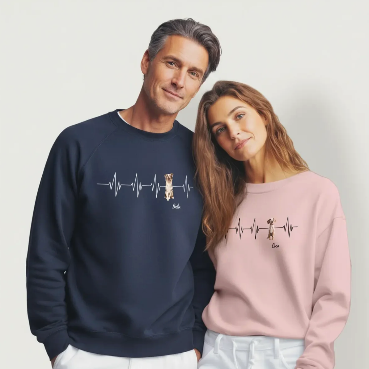 Two personalized sweatshirts in dark blue and pink with heartbeat design and dog motifs.