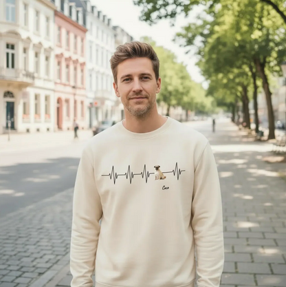 Beige sweatshirt with heartbeat design and dog, worn by a man in a cityscape.
