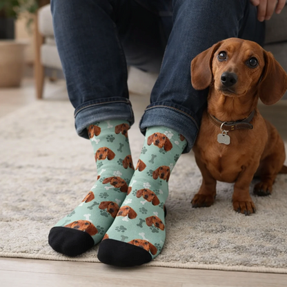 Personalized mint green socks with dog motif and black foot, worn by a person. Dog sitting next to them.
