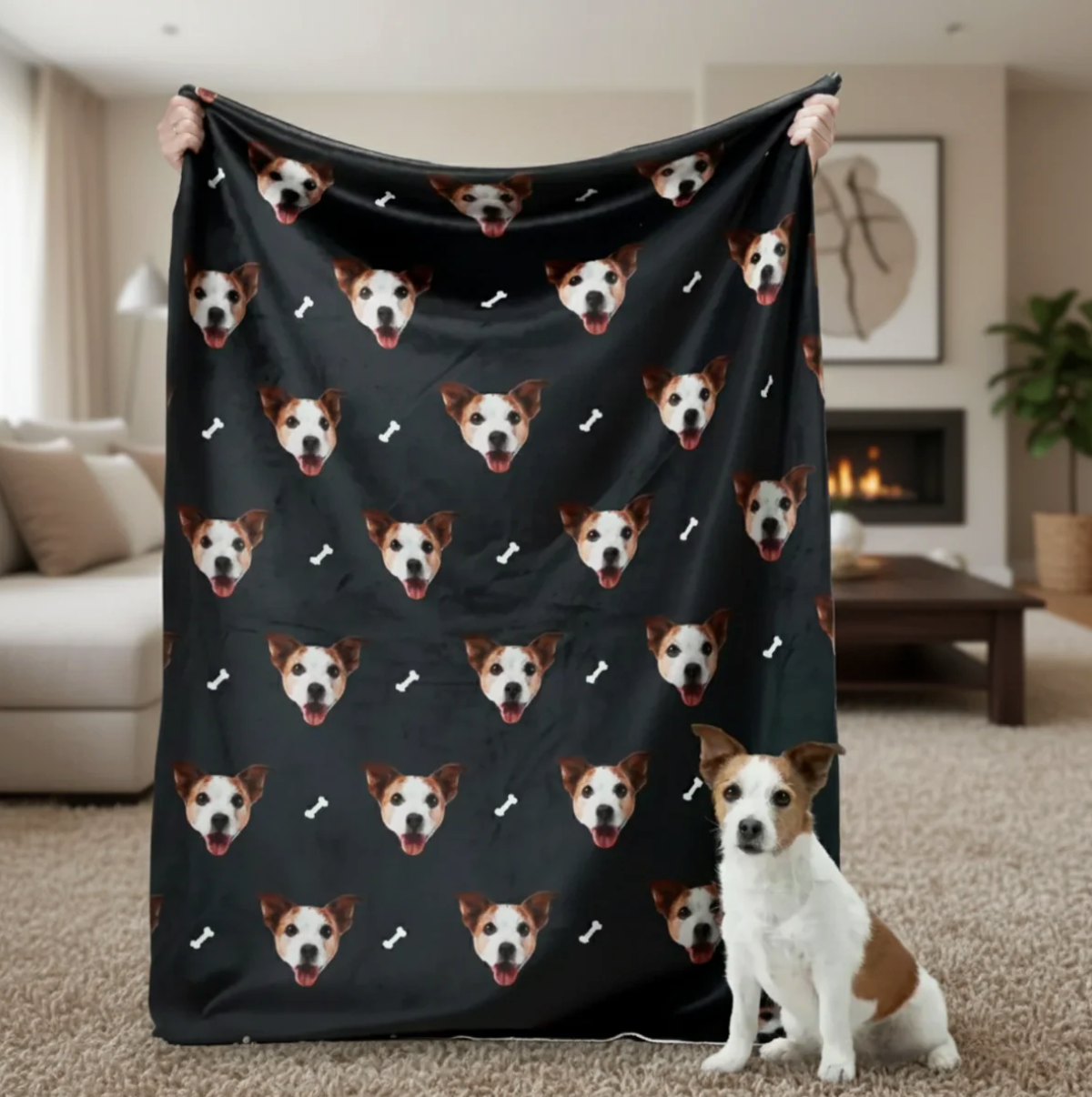 Personalized blanket with pet heads on a black background, held by a person with a dog in the foreground.