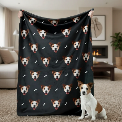 Personalized blanket with pet heads on a black background, held by a person with a dog in the foreground.