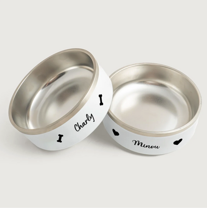 Personalized stainless steel pet bowls with white exterior, printed with the names Charly and Minou.