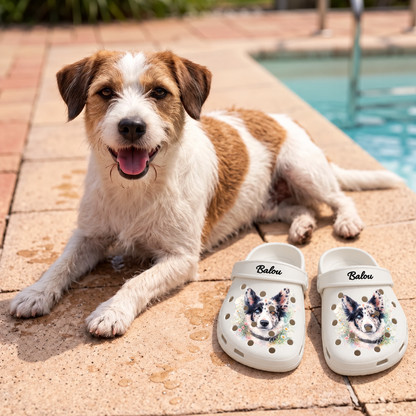 Personalized white clogs with a watercolor dog print and the name Balou, lying on the floor.
