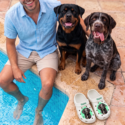Person sitting next to two dogs by the pool, personalized white clogs with pet portrait beside them.